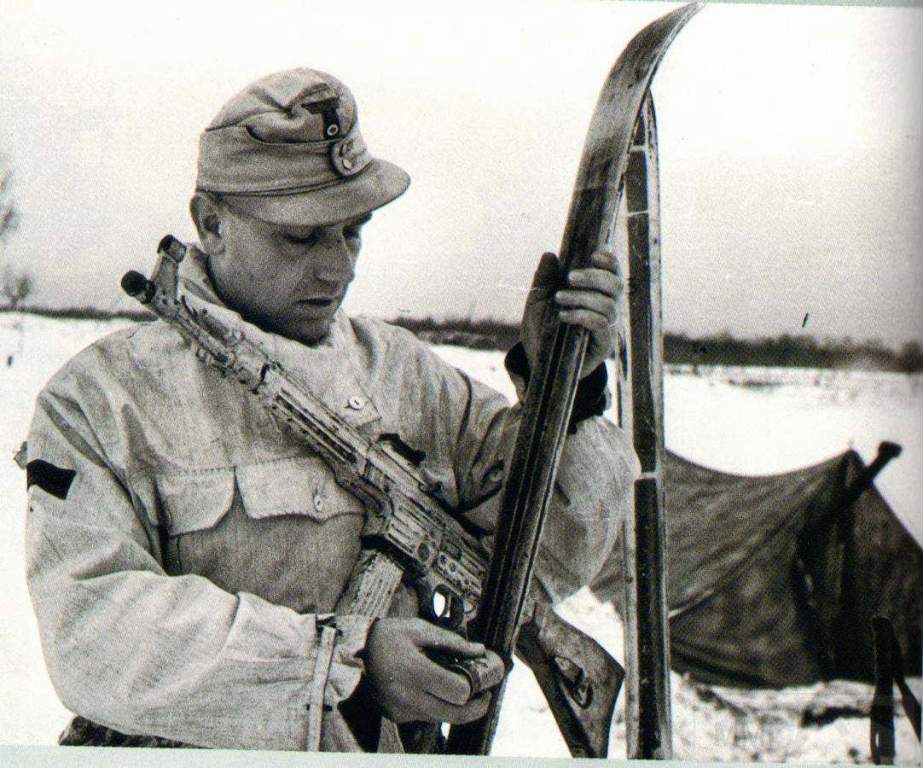 1719 - A German soldier of the 1. Skijäger-Division, armed with a StG 44, prepares his skis. Ukraine, 1944.