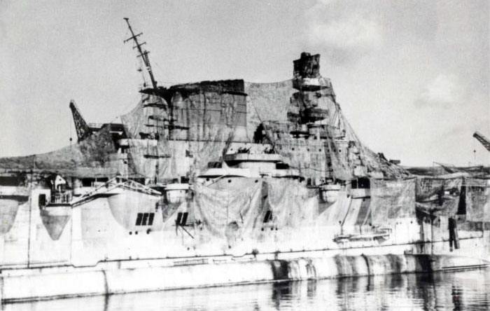 8613 - A close-up of Aquila’s island superstructure draped with camouflage netting at Genoa in August 1943